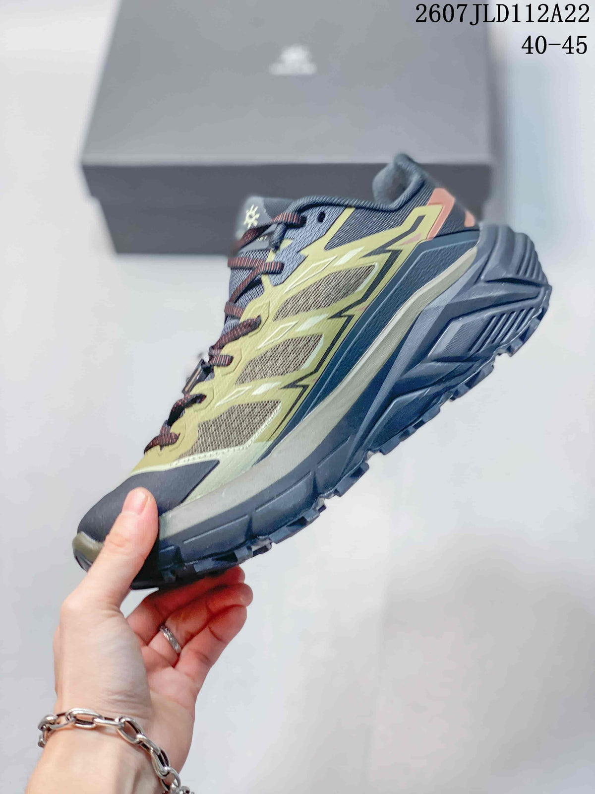 Side view showing the mesh upper, layered olive overlays, protective toe area, and thick outdoor outsole.