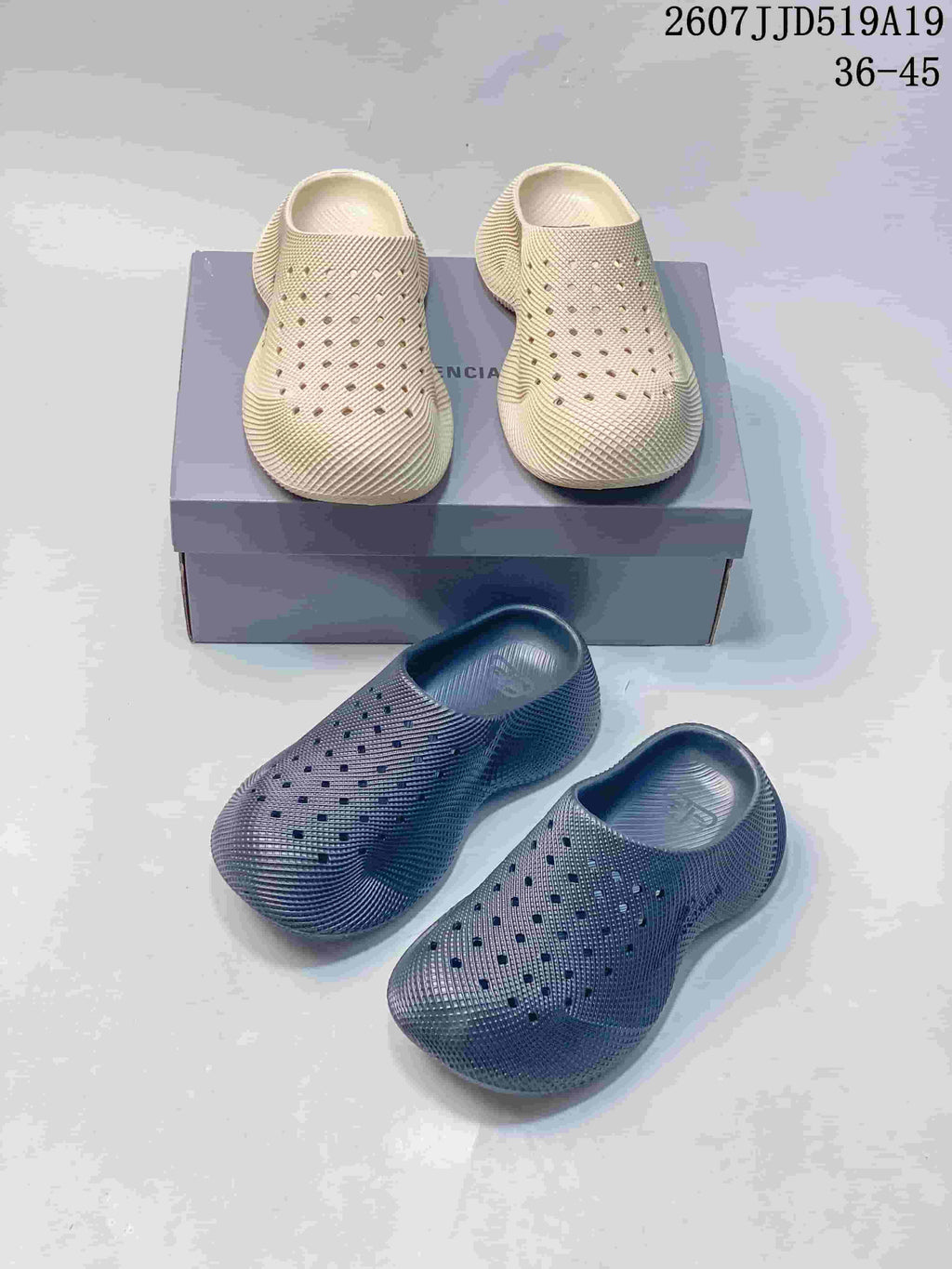 Cream and dark gray pairs of perforated slip-on clogs arranged around a product box.