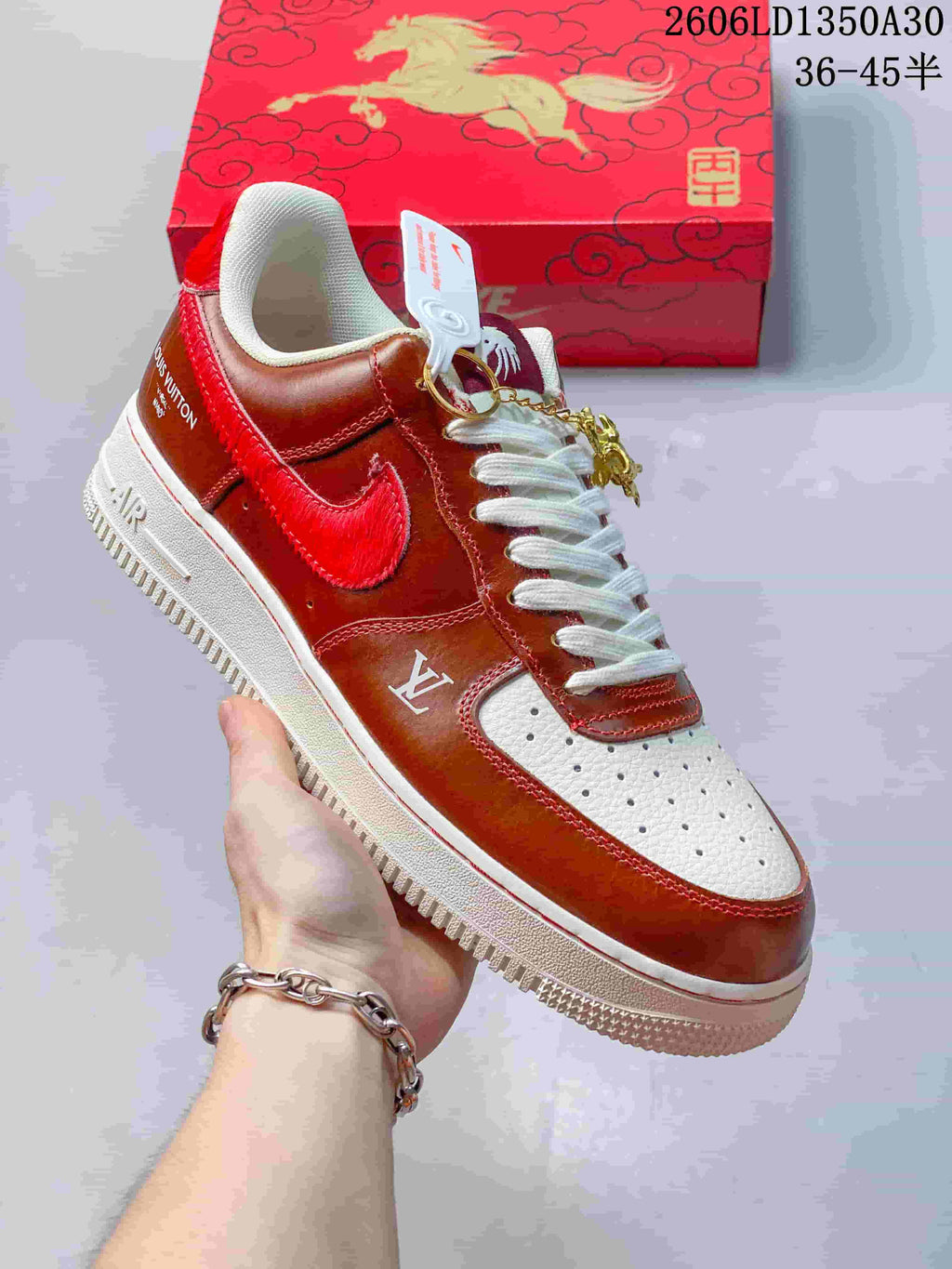 Close-up of a brown and red low-top sneaker with white panels and a horse charm.