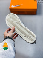Underside view of a sneaker showing the white rubber outsole and its repeating herringbone tread pattern.