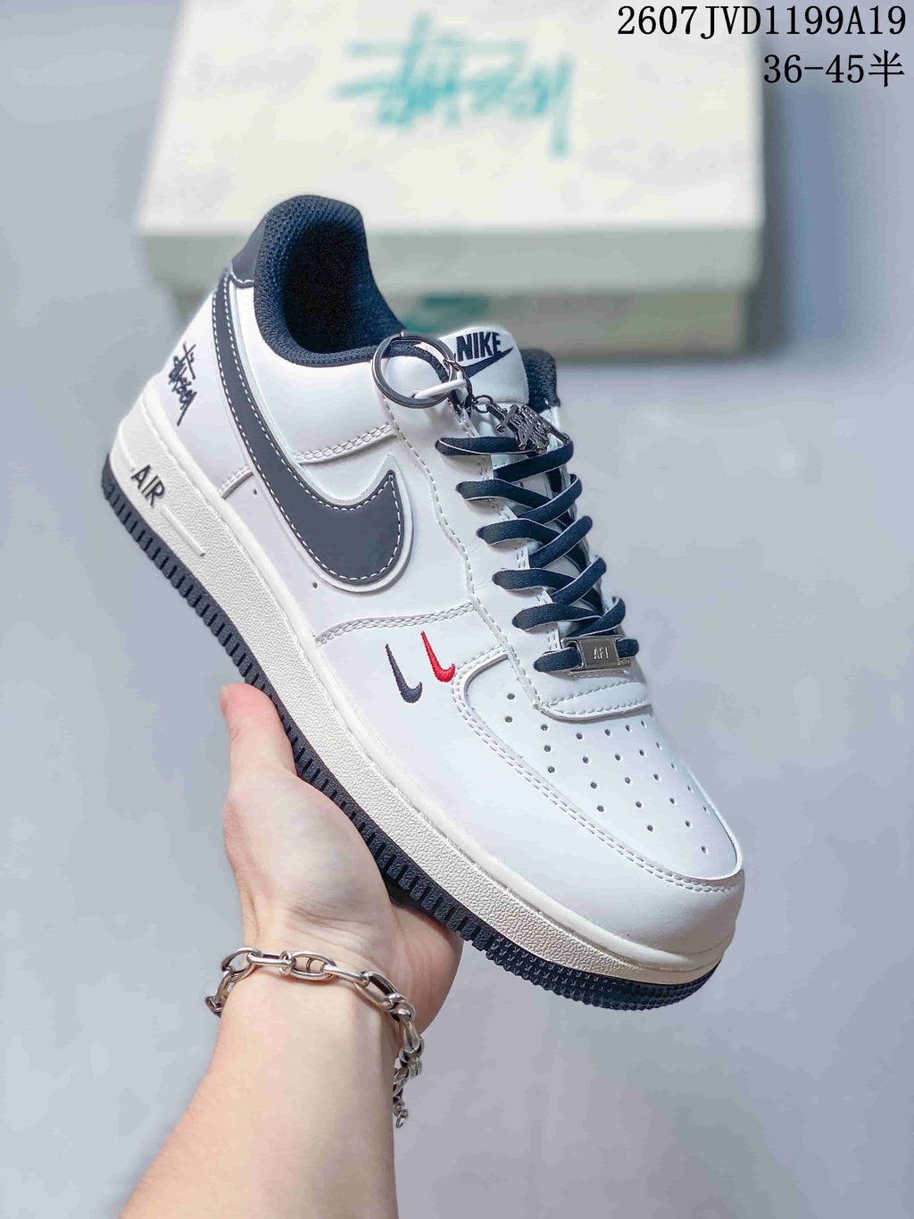 Side view of a white Nike low-top sneaker showing the dark Swoosh, Air midsole branding, patterned heel detail, perforated toe, and lace hardware.