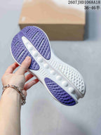 Outsole view showing purple traction sections, a white midsole, and molded circular cushioning details.