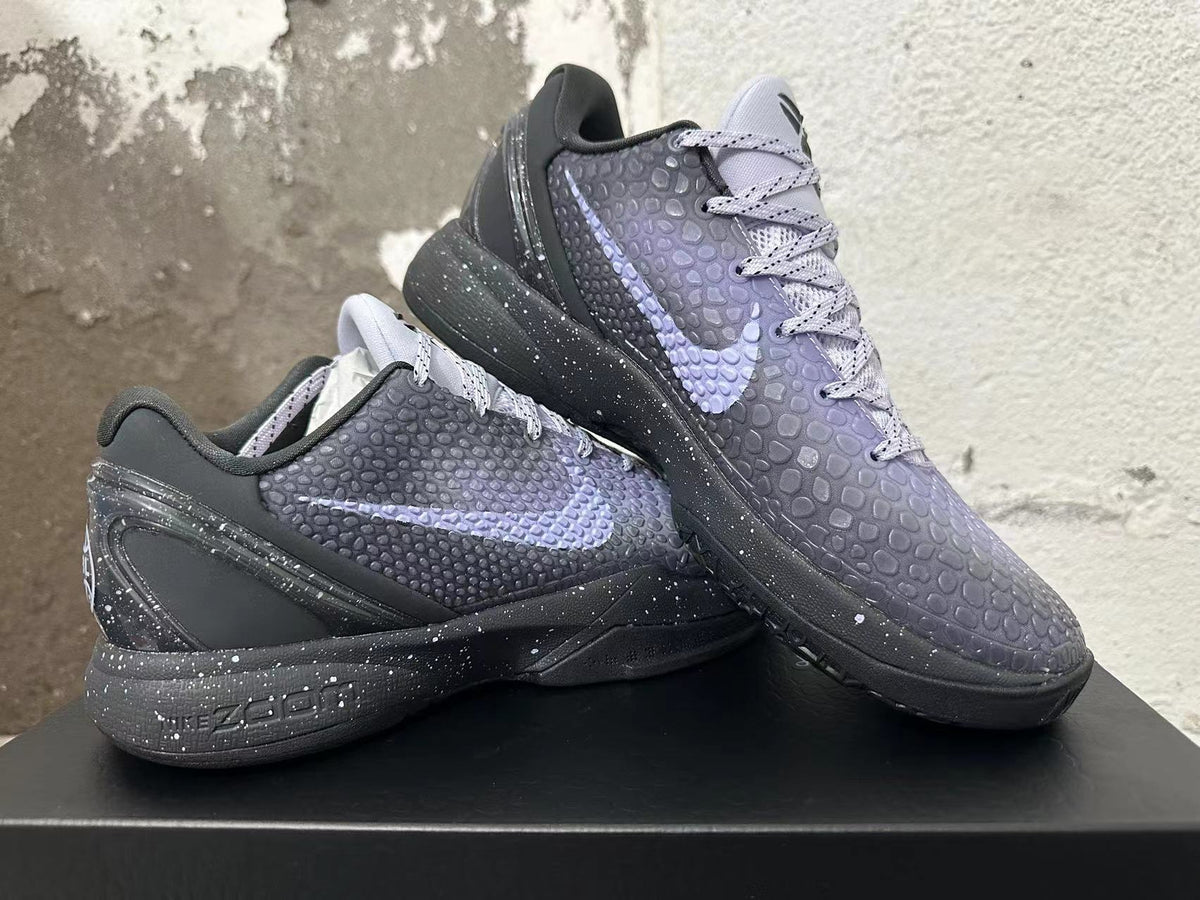 Two black and purple Kobe 6 shoes shown in a crossed side profile