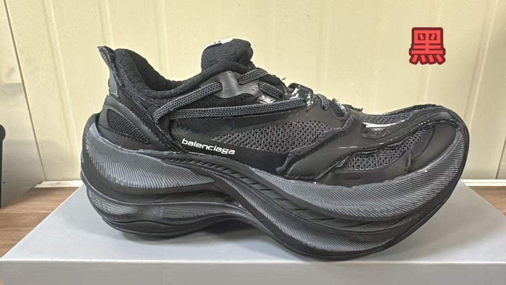 Black Balenciaga sneaker with mesh panels, layered overlays, and a chunky textured sole.