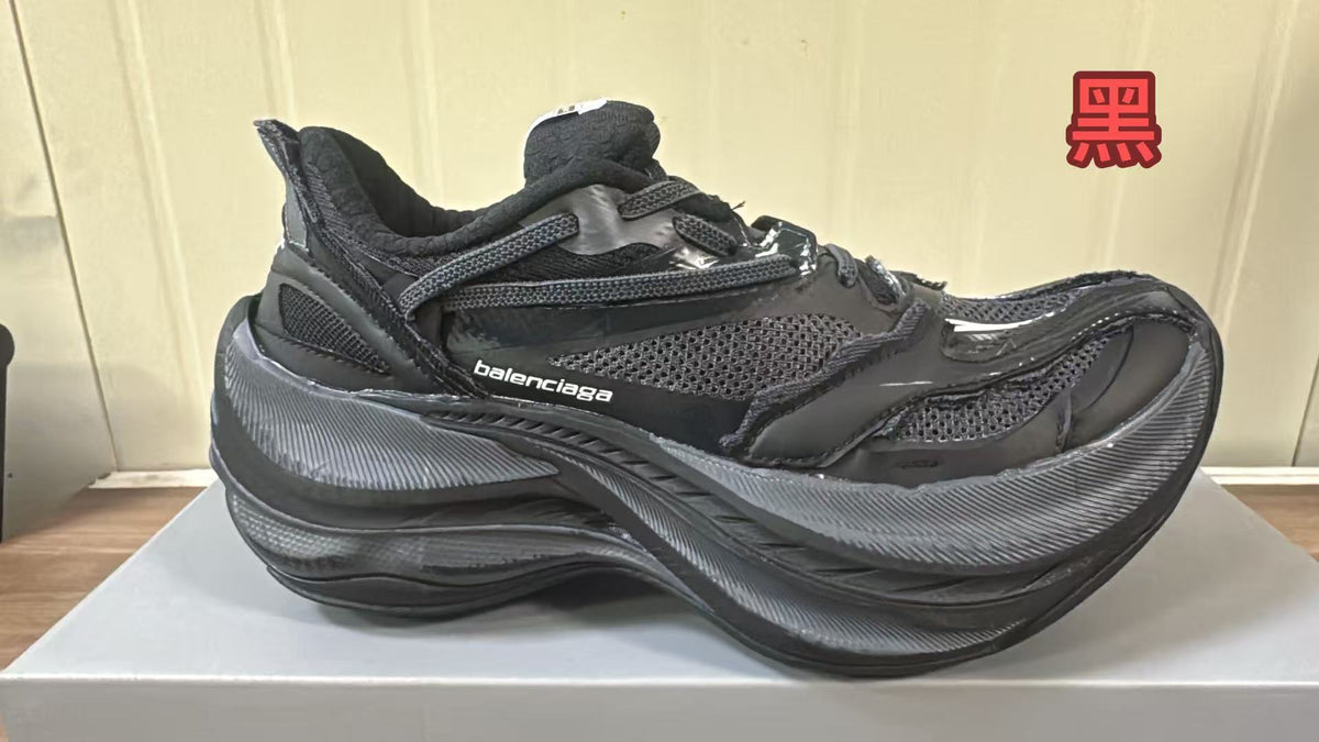 Black Balenciaga sneaker with mesh panels, layered overlays, and a chunky textured sole.