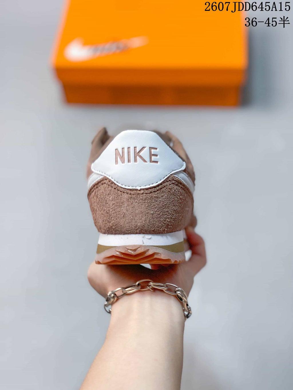 Rear view of the brown sneaker showing the white Nike heel detail, layered sole, and gum-colored outsole.