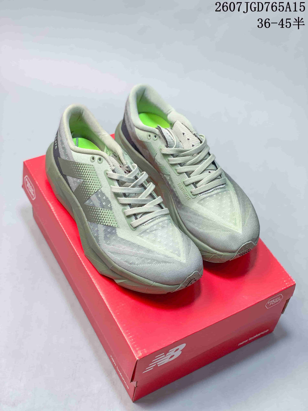 Pair of gray New Balance running shoes with muted purple accents displayed on a red shoebox.