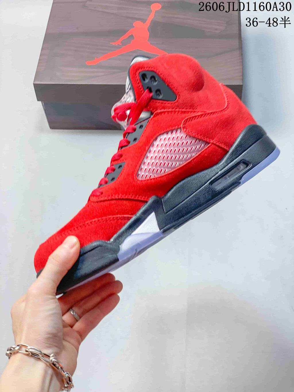 Side view of the red high-top sneaker showing its mesh panel and dark midsole.