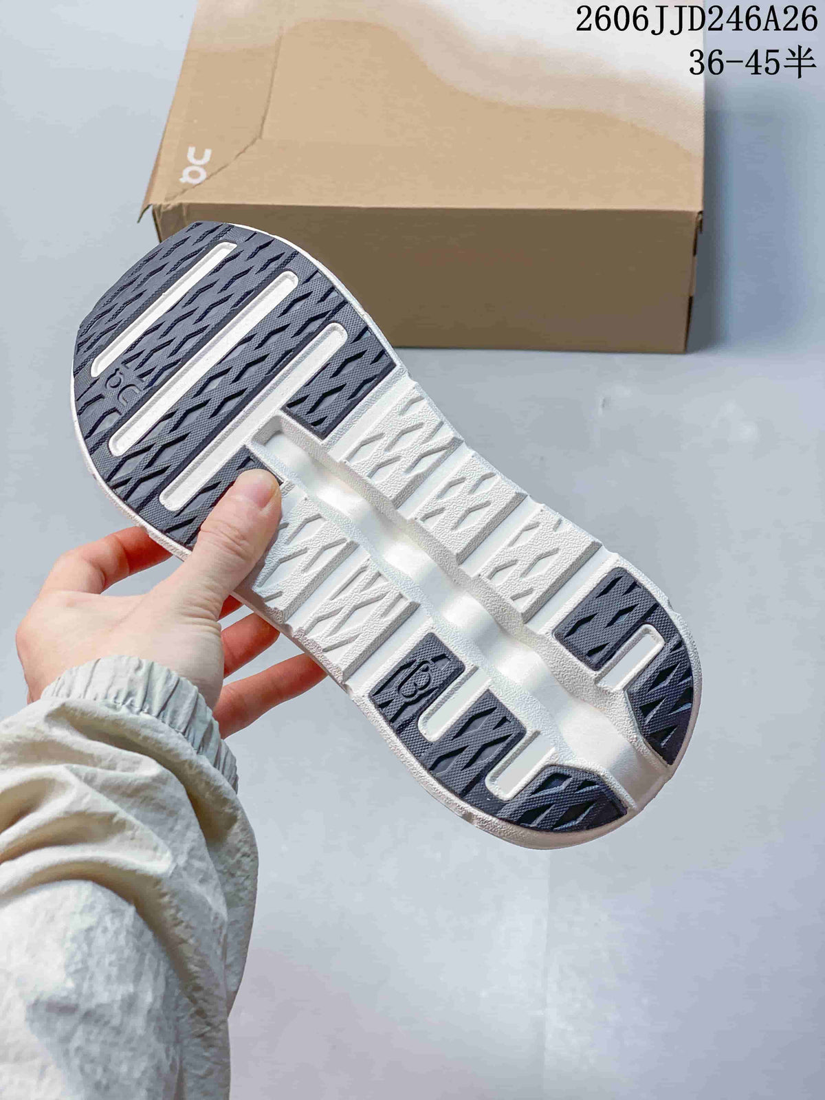 Close view of the sneaker outsole showing dark traction sections and a sculpted white sole.