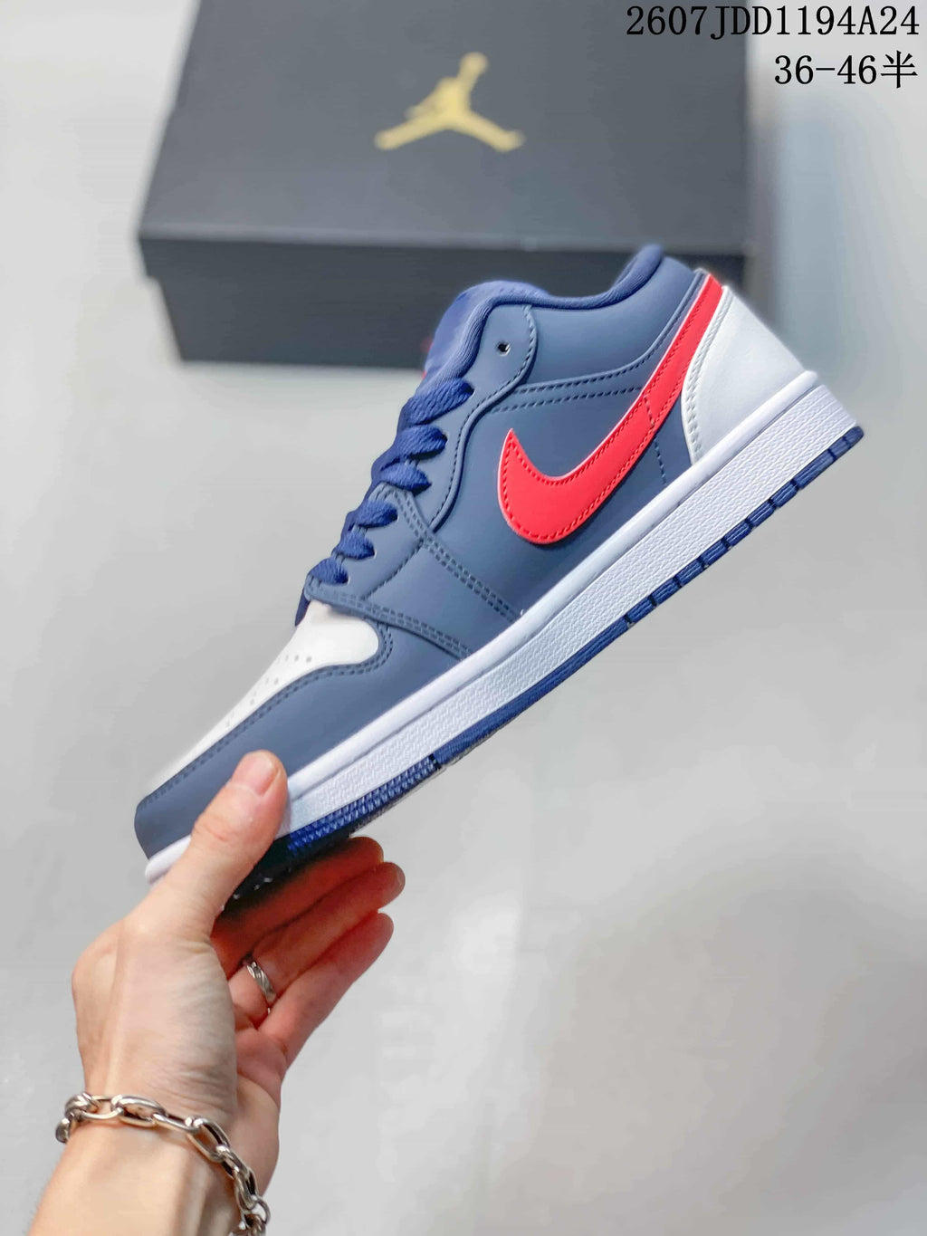 Side profile showing the navy upper, red side branding, white midsole, and navy outsole.