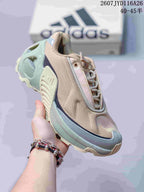 Three-quarter front view showing the beige upper, mint and gray sole layers, laces and toe design.