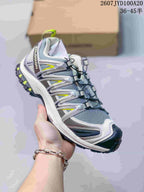 Gray and white Salomon XA PRO 3D trail shoe with bright yellow accents and a dark outsole.