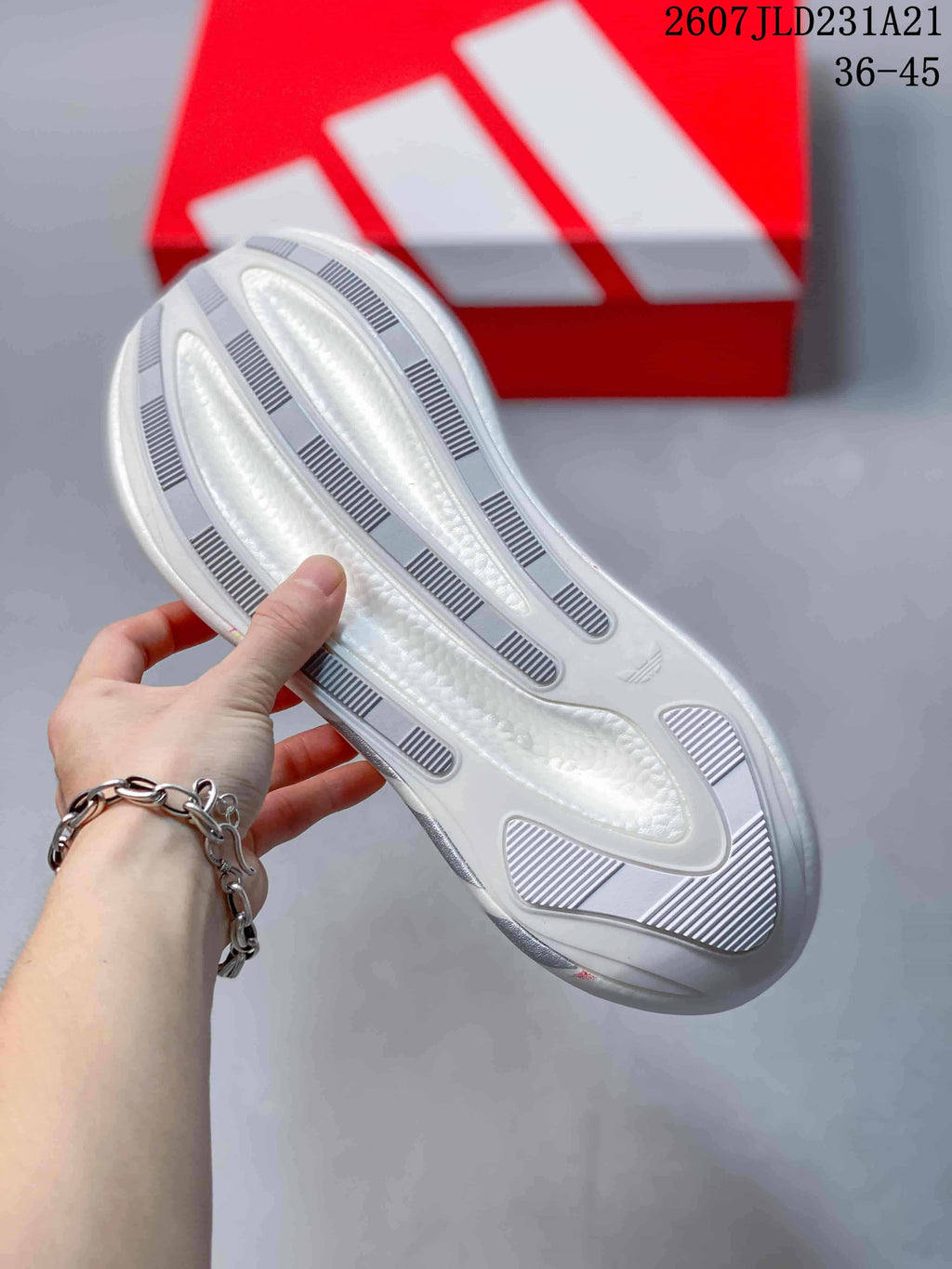 Close-up of the white outsole showing elongated grey traction inserts and a textured central section.