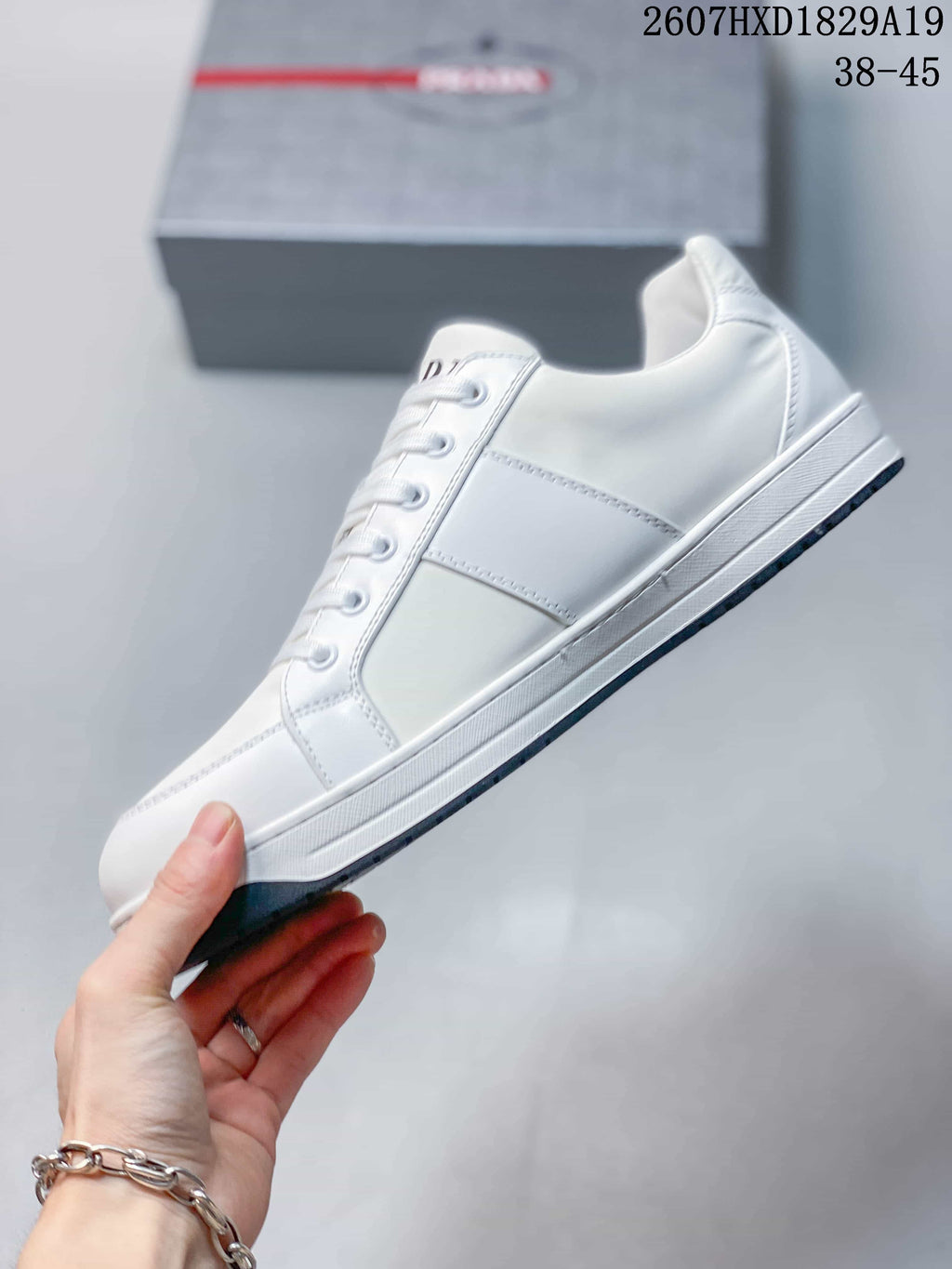Side profile of the white lace-up sneaker showing its panel construction, tonal stitching and low-profile sole.
