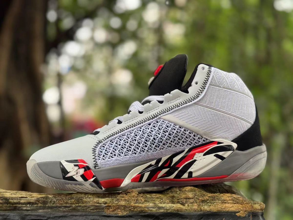 Angled side view showing the white upper, patterned side panel, and red and black details.