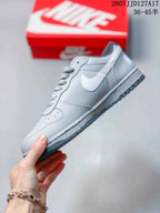 Side profile showing the grey upper, white Swoosh, layered panels, lace system, and dark outsole.