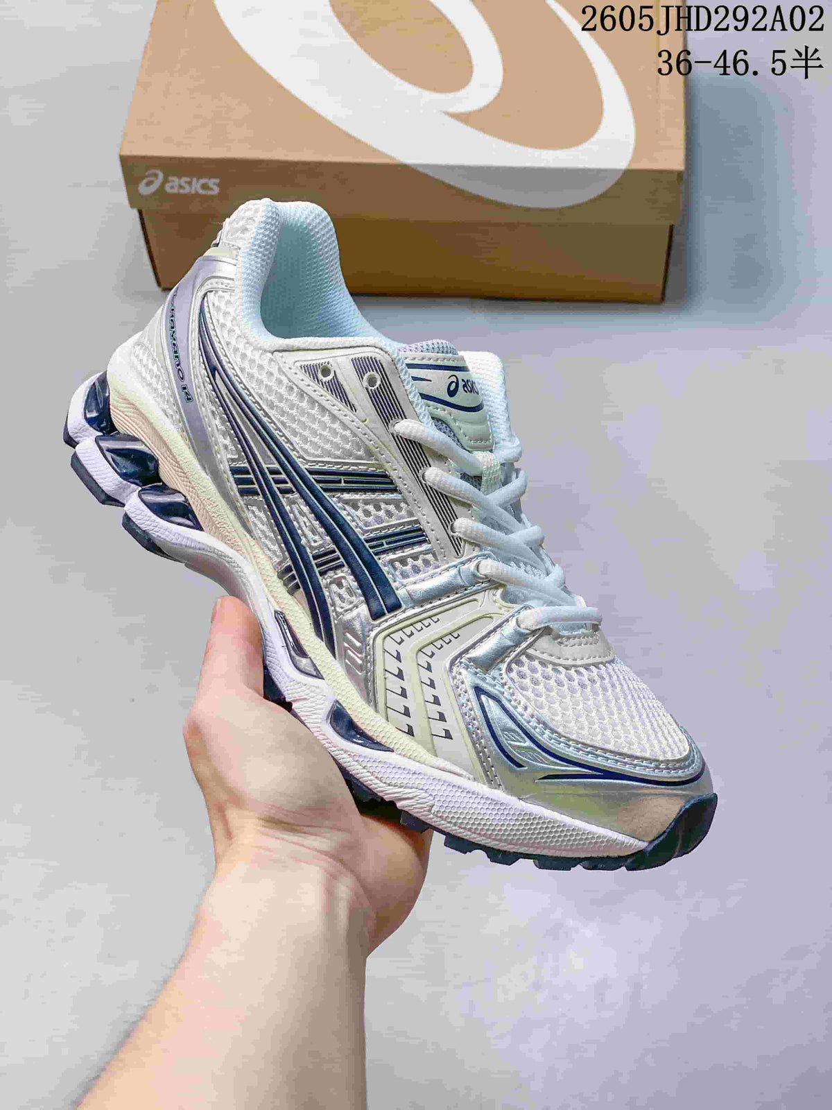 ASICS GEL-KAYANO 14 sneaker in white and silver with blue details, shown at an angled front-side view.