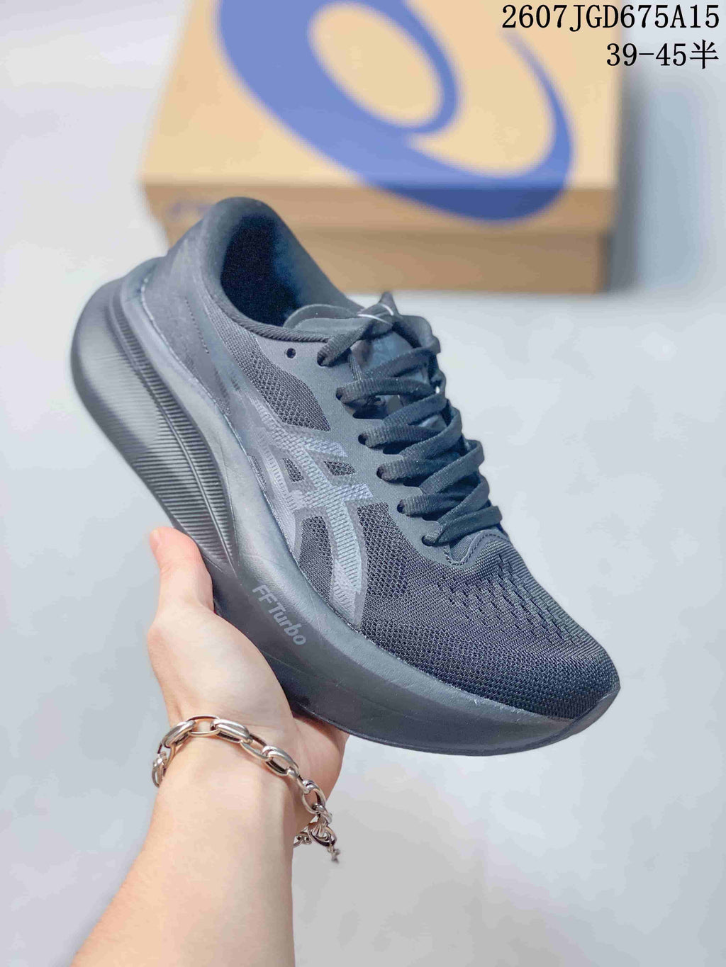 Three-quarter side view of the dark gray ASICS running shoe showing the mesh upper, lace system, and thick outsole; overlay text shows product code 2607TGD675A15 and a 39–45 half-size range.