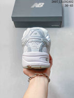 Rear view of the white and grey New Balance 509 sneaker showing the padded heel area and layered heel construction.