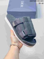 Close view of a grey sandal showing its layered straps, textured footbed, and branded detail; image shows size range 39–46.