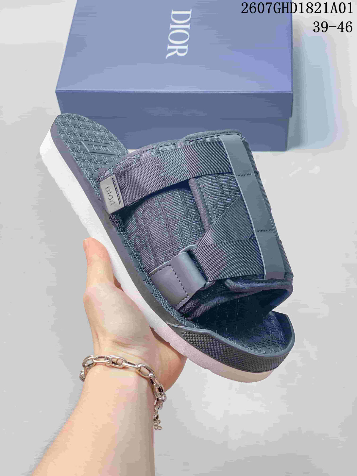 Close view of a grey sandal showing its layered straps, textured footbed, and branded detail; image shows size range 39–46.
