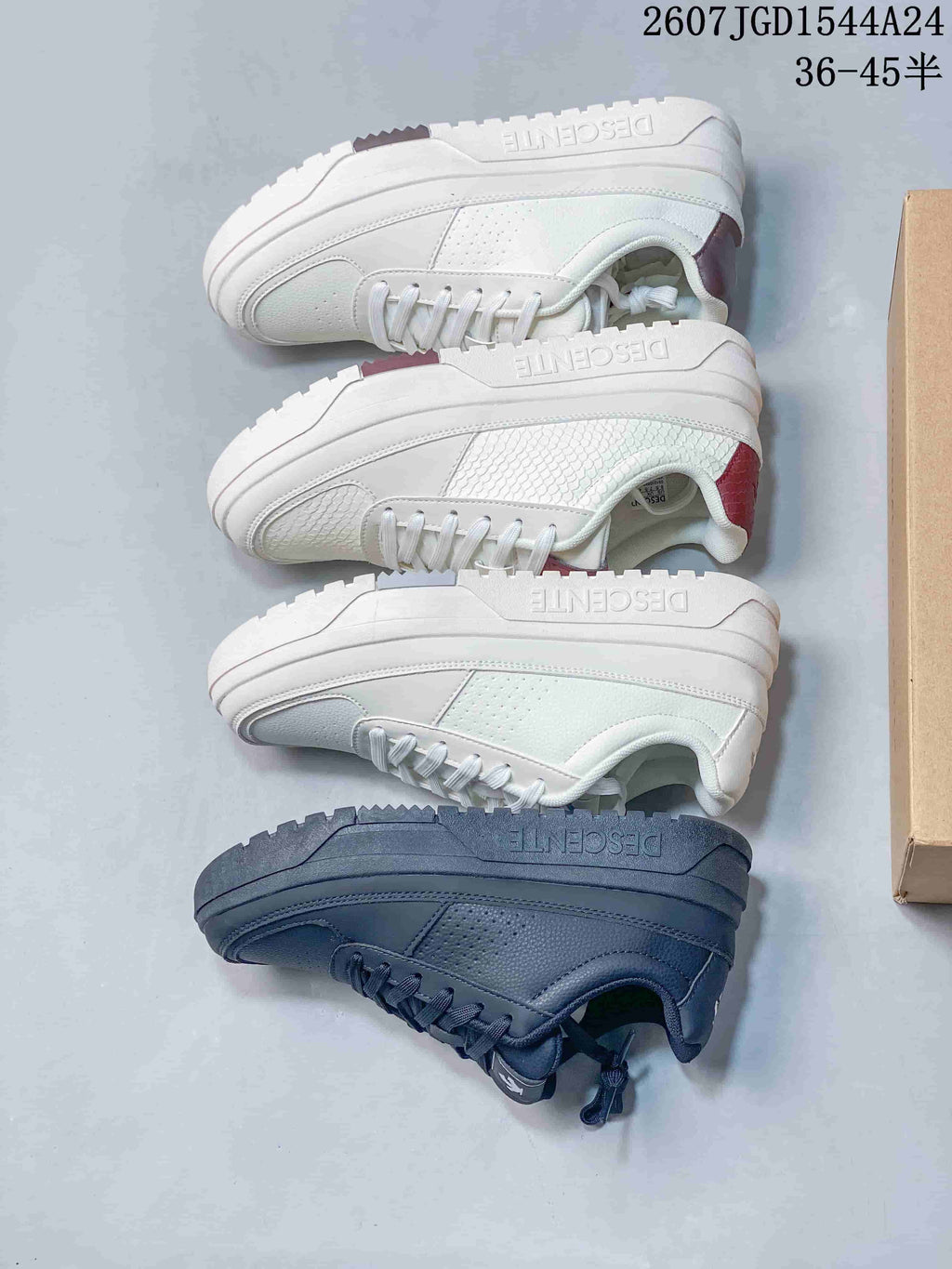 Top-down view showing multiple white and navy DESCENTE Dualis sneakers with contrasting heel accents.
