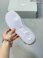 Underside of the white sole on a beige and white Nike Air Force 1 '07 sneaker
