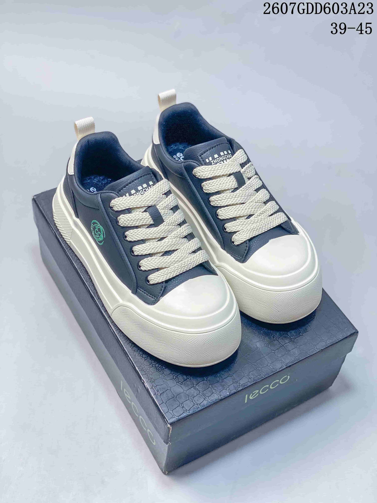 Pair of navy and white ECCO sneakers displayed on a branded shoe box; code 2607GDD603A23 and size range 39–45 are visible.