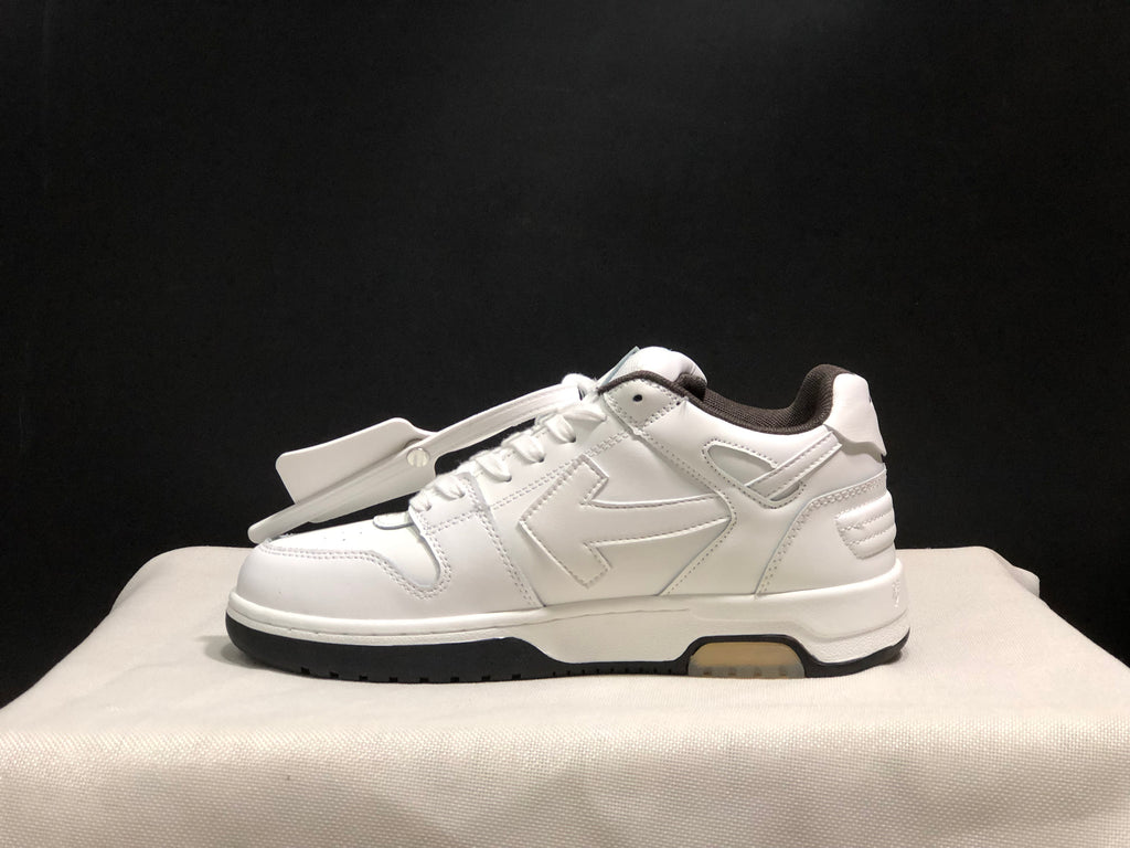 Profile view of a white low-top sneaker showing the tonal side detailing, padded collar, and black outsole edge.