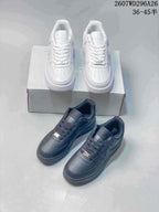 White and black pairs of low-top sneakers shown together in front of a shoebox.