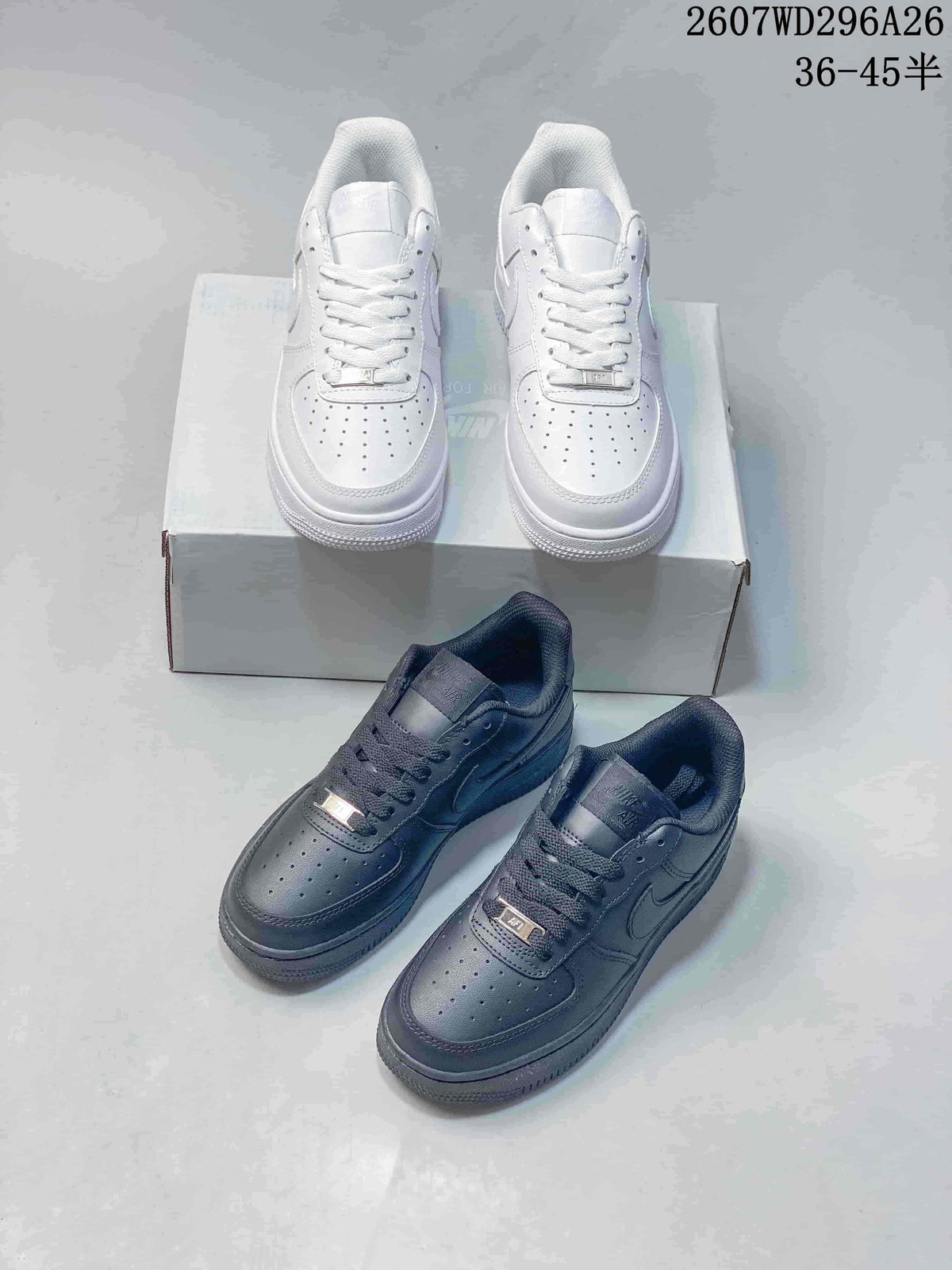 White and black pairs of low-top sneakers shown together in front of a shoebox.