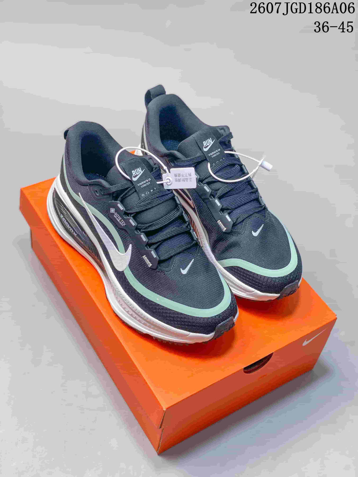 Pair of dark navy and mint Nike running shoes displayed on an orange shoebox, with a visible 36–45 size range marking.