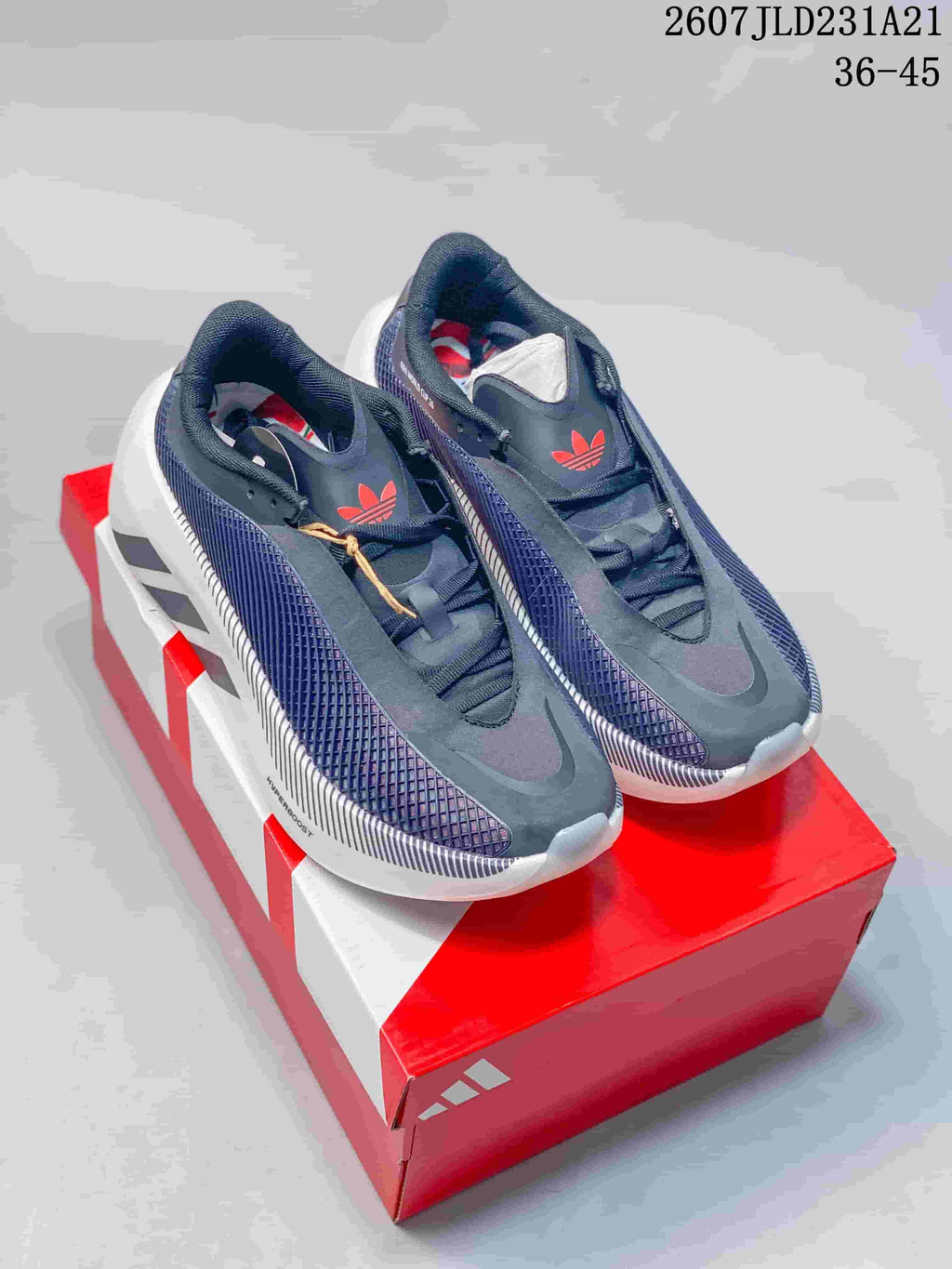 Pair of dark navy and white Adidas Hyperboost EDGE sneakers displayed on a red Adidas shoebox.
