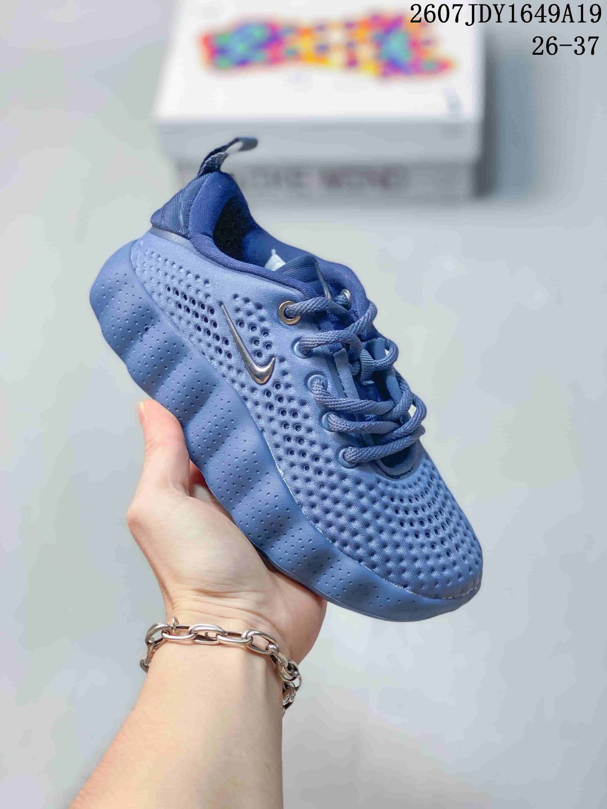 Blue Nike Mind 002 kids sneaker with matching laces, pull tab and textured outsole.