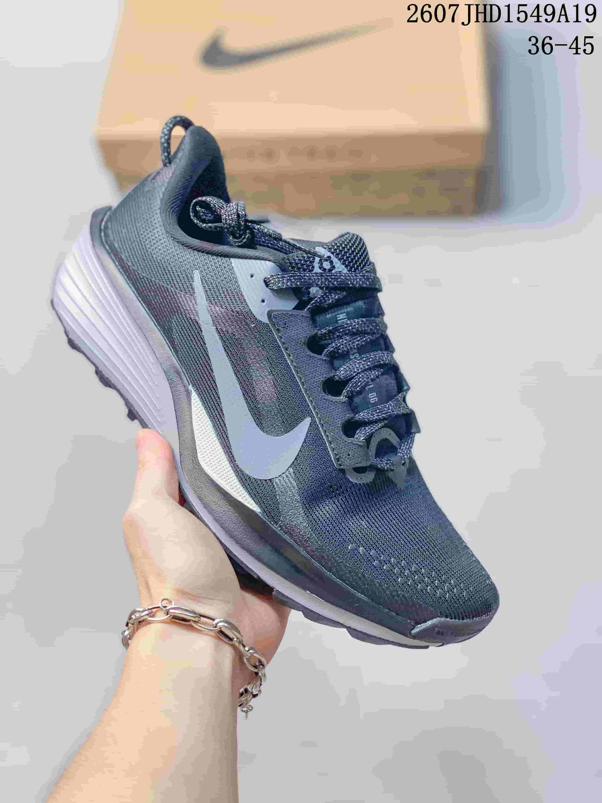 Dark gray Nike Zoom Fly 5 sneaker with a pale blue Swoosh and contrasting layered sole.