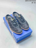 Pair of black adidas Samba OG mule sneakers displayed on a blue adidas shoebox