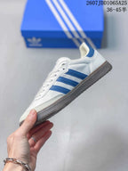 Side profile showing the white upper, blue three stripes, lace-up front, and gum-colored sole.