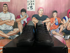 Front view of black textured basketball shoes with black laces and blue accents