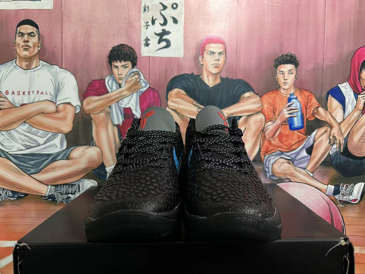 Front view of black textured basketball shoes with black laces and blue accents