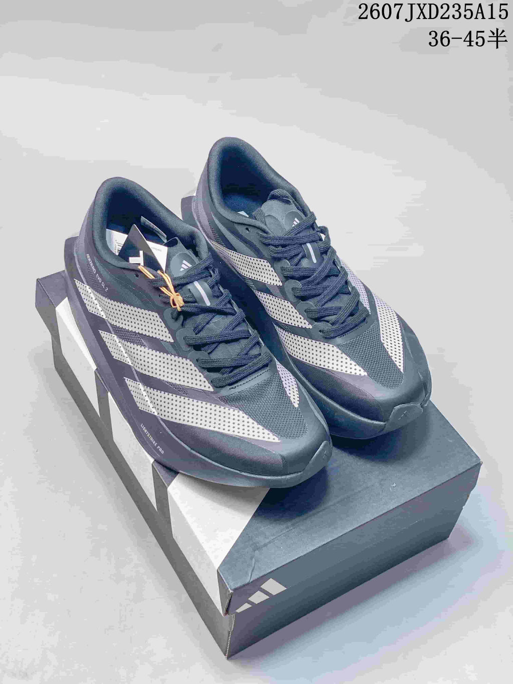 Pair of dark gray and white adidas Adizero Evo SL 2 running shoes displayed on a shoebox.