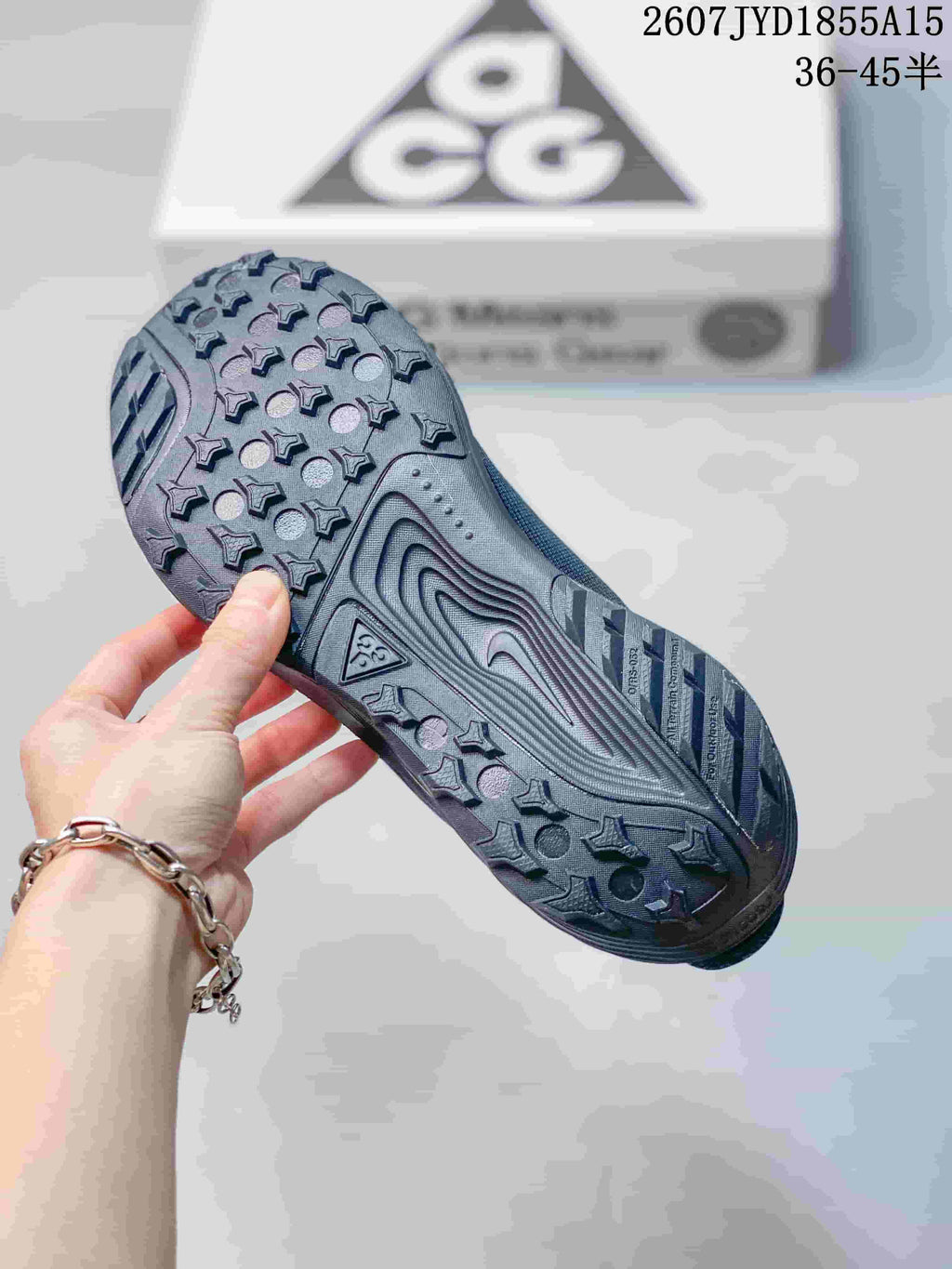 Close view of the patterned lugged outsole on a dark gray Nike ACG Pegasus Trail sneaker.