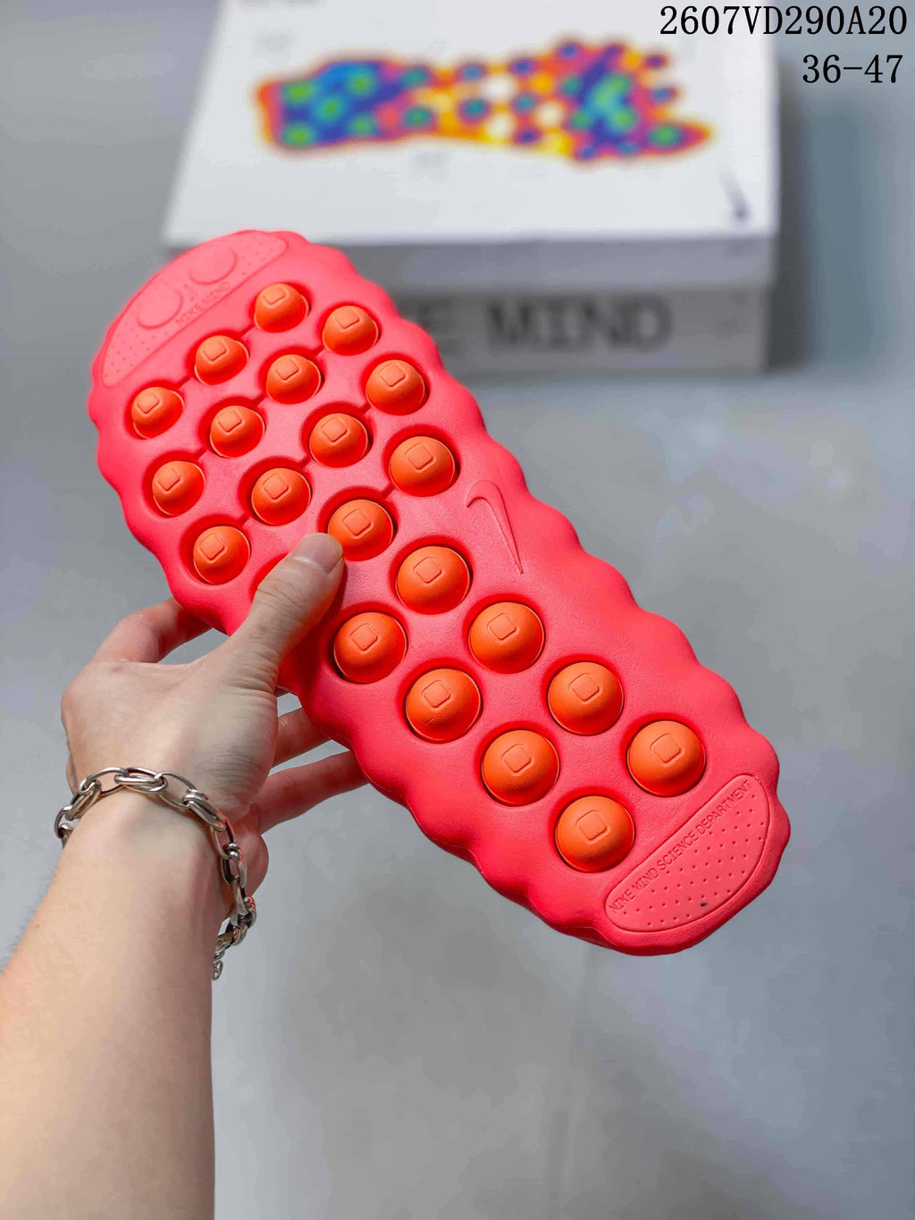 Underside of a red slide showing raised circular outsole elements and a textured sole pattern.