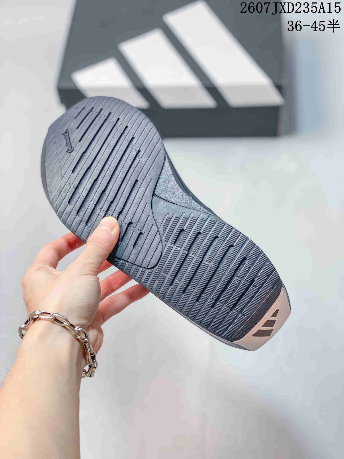 Close view of the grooved dark outsole and tread pattern of the adidas running shoe.