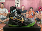 Side view showing gold Nike logo, multicolor graphic panels, and green outsole