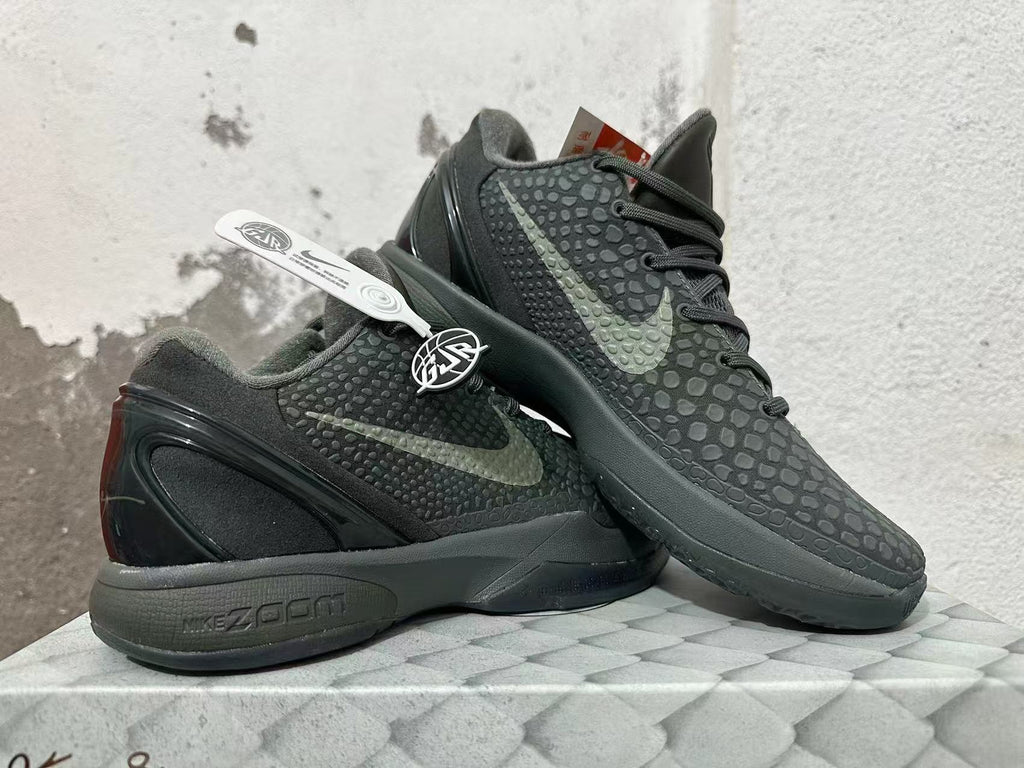 Pair of dark Nike Kobe 6 shoes shown from the side, highlighting the textured finish and heel design