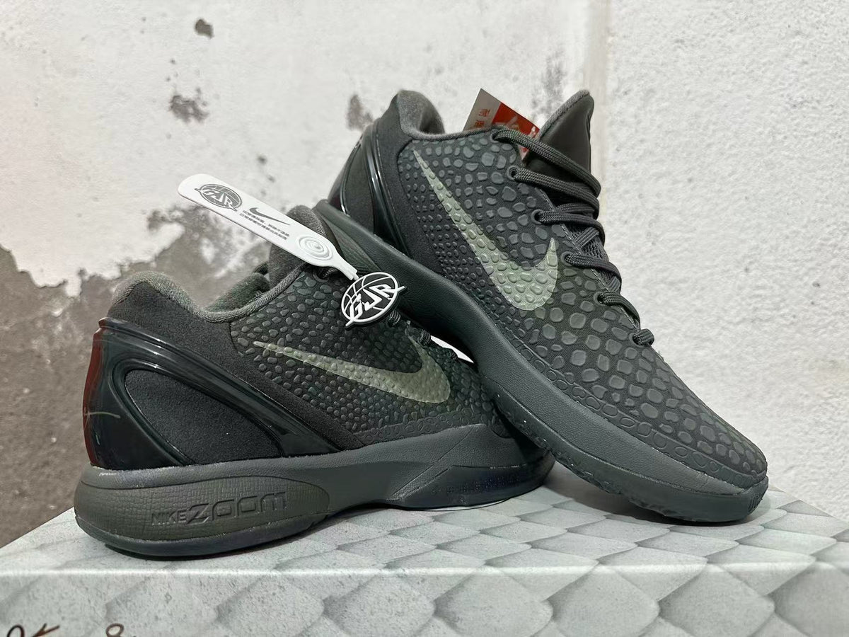 Pair of dark Nike Kobe 6 shoes shown from the side, highlighting the textured finish and heel design