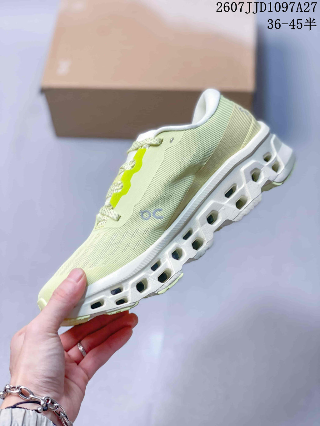 Side profile of the pale green sneaker showing the grey On logo, lace area and open-section outsole.
