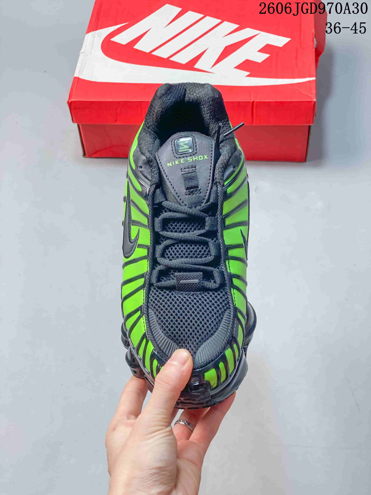 Front view of a black and green lace-up sneaker