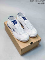 Pair of white and blue DESCENTE Cron Tempo sneakers displayed on a shoebox.