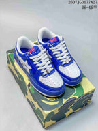 Pair of blue and white BAPE STA low-top sneakers displayed on a camouflage-patterned box; source image shows the reference 2607JGD677A27 and size range 36–46.5.